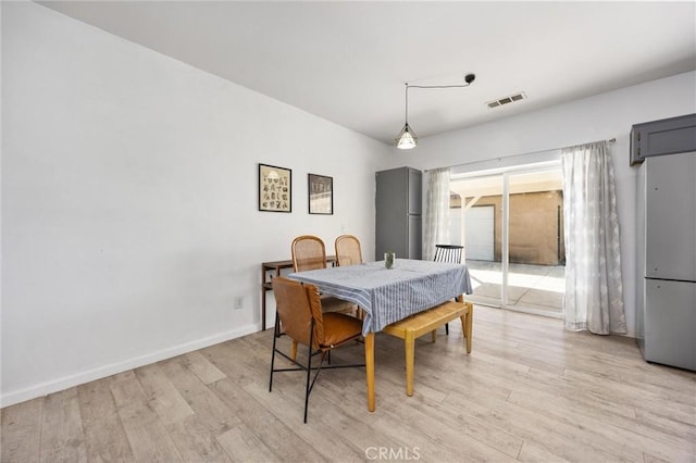 dining area featuring visible vents, light wood-type flooring, and baseboards