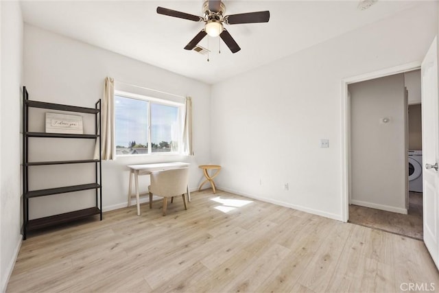 home office featuring visible vents, ceiling fan, baseboards, wood finished floors, and washer / clothes dryer