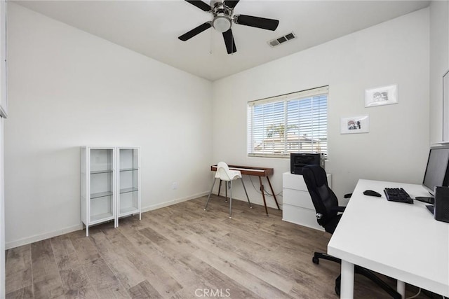 office area with light wood finished floors, visible vents, baseboards, and a ceiling fan