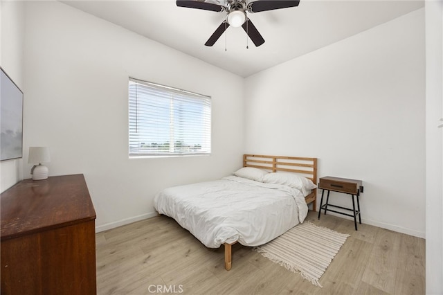 bedroom featuring a ceiling fan, light wood-type flooring, and baseboards