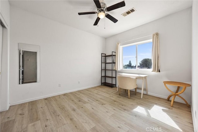 home office featuring visible vents, a ceiling fan, baseboards, and wood finished floors