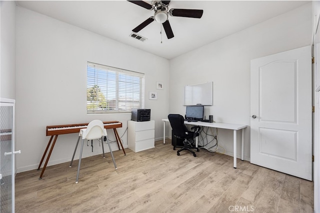 office area with visible vents, baseboards, light wood-type flooring, and ceiling fan