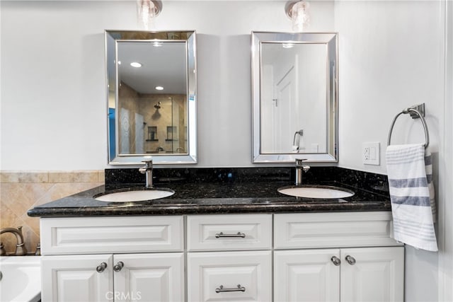 full bath with double vanity, a shower with door, and a sink