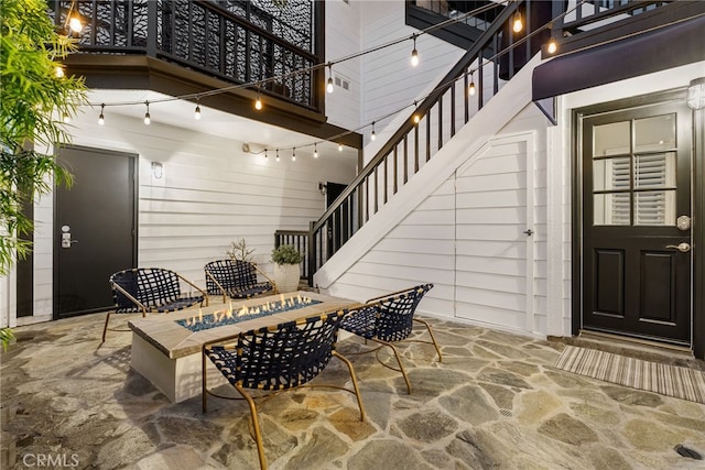 view of patio with stairway and a fire pit