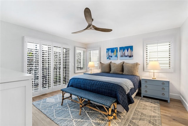 bedroom featuring access to outside, a ceiling fan, baseboards, and light wood finished floors