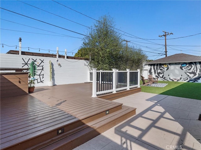 wooden terrace featuring a fenced backyard and an outdoor structure