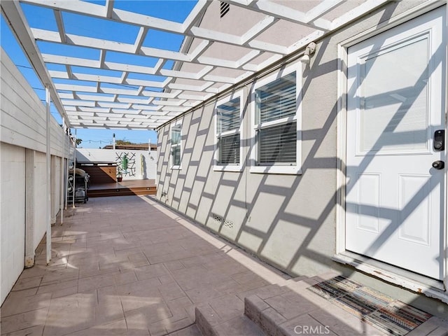 view of patio featuring a wooden deck and a pergola