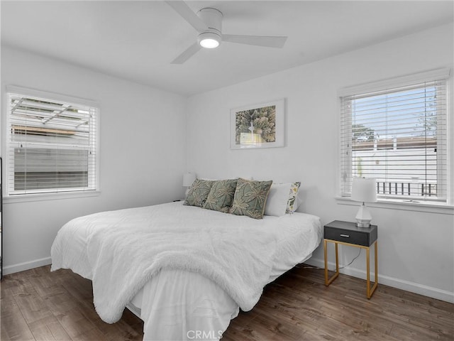 bedroom featuring baseboards, wood finished floors, and a ceiling fan