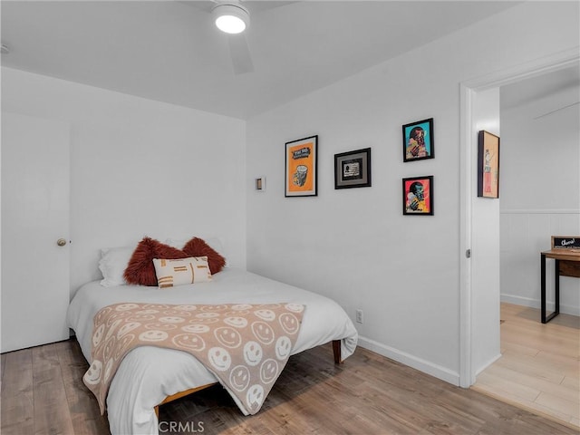 bedroom with ceiling fan, baseboards, and wood finished floors