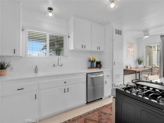 kitchen with stainless steel dishwasher, light countertops, visible vents, and black gas stove