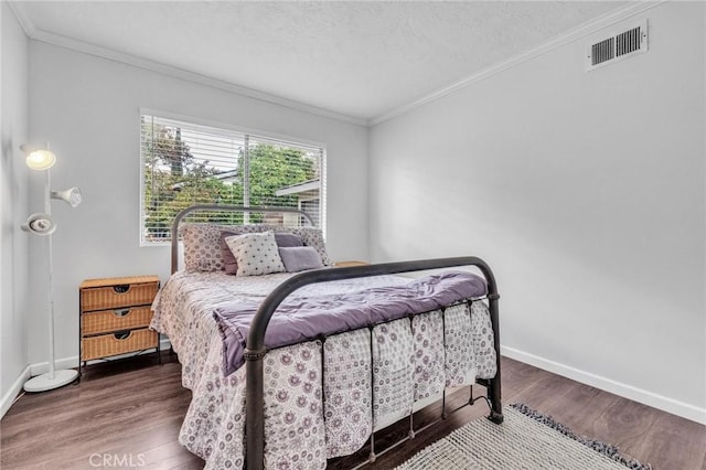 bedroom featuring visible vents, wood finished floors, and ornamental molding