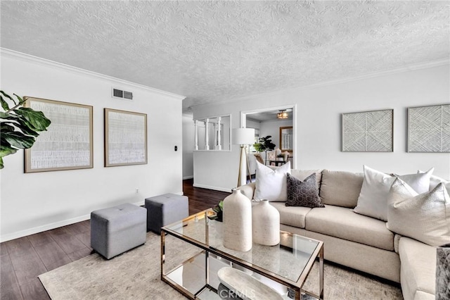 living room with visible vents, ornamental molding, a textured ceiling, and hardwood / wood-style flooring