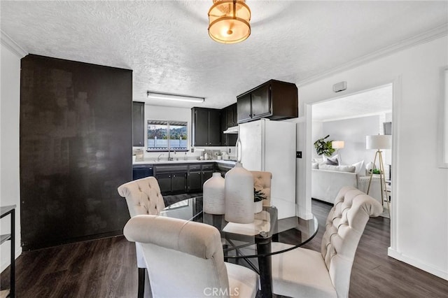 dining area featuring baseboards, a textured ceiling, dark wood-style floors, and crown molding