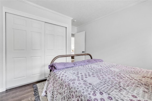 bedroom featuring crown molding, wood finished floors, a closet, and a textured ceiling