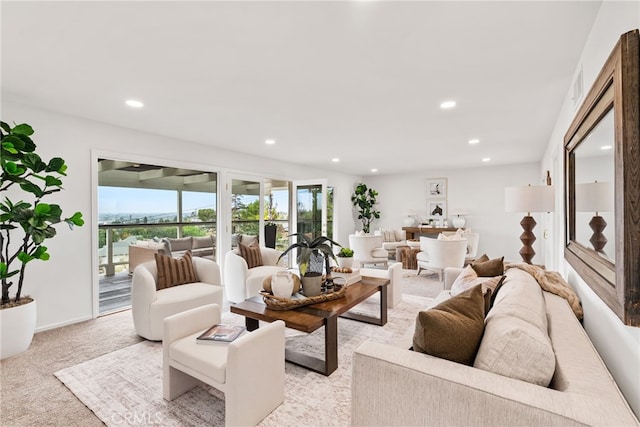 living room featuring recessed lighting, baseboards, and light colored carpet