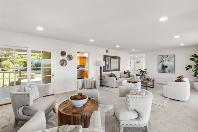 living room with light colored carpet, recessed lighting, visible vents, and baseboards