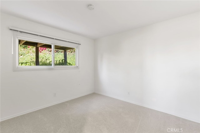 empty room with baseboards and light carpet