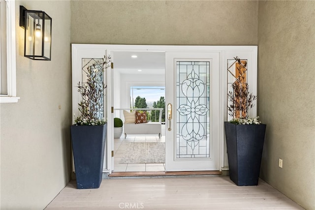 entryway featuring wood finished floors and a textured wall