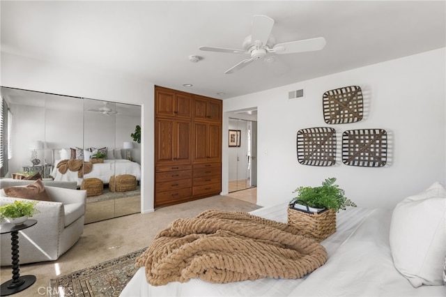 bedroom featuring a ceiling fan, light colored carpet, visible vents, and a closet