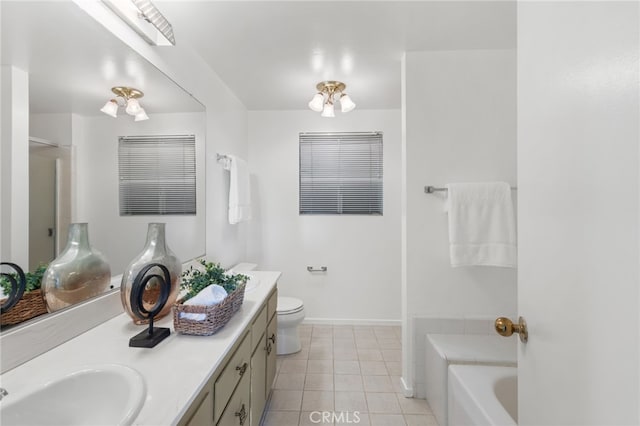 bathroom featuring vanity, baseboards, tile patterned flooring, toilet, and a bathtub