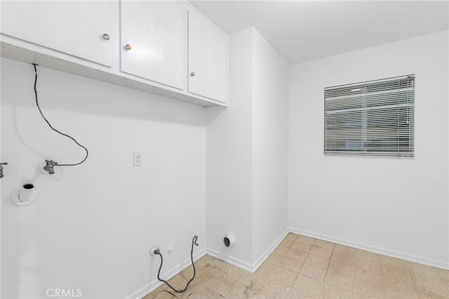 laundry room with cabinet space and baseboards