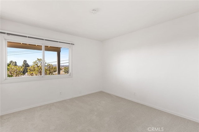 empty room with baseboards and light carpet