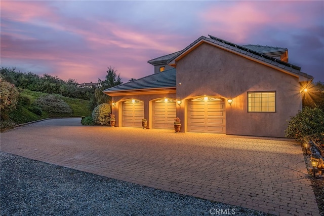 3221 Integrity Way, Fallbrook, CA 92028 - view of front of property featuring an attached garage, roof mounted solar panels, stucco siding, and driveway