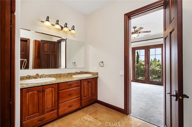 full bathroom with a sink, baseboards, ceiling fan, and double vanity