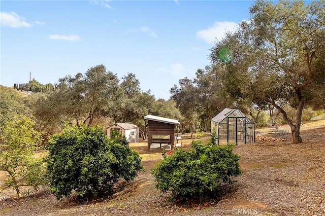 view of yard with an outbuilding and a greenhouse