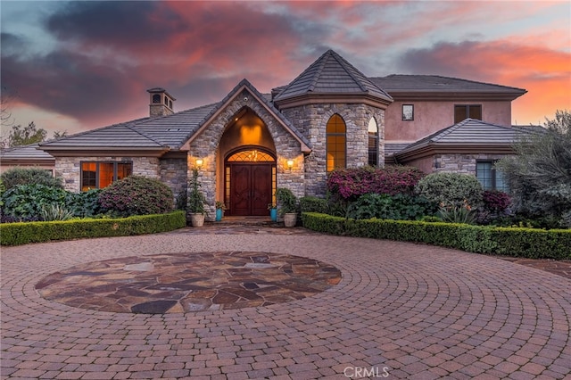 3221 Integrity Way, Fallbrook, CA 92028 - french country style house with stone siding, curved driveway, stucco siding, and a chimney