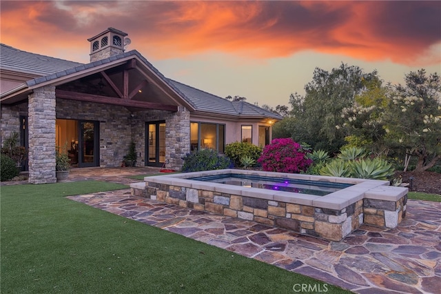 exterior space featuring a yard, an in ground hot tub, and french doors