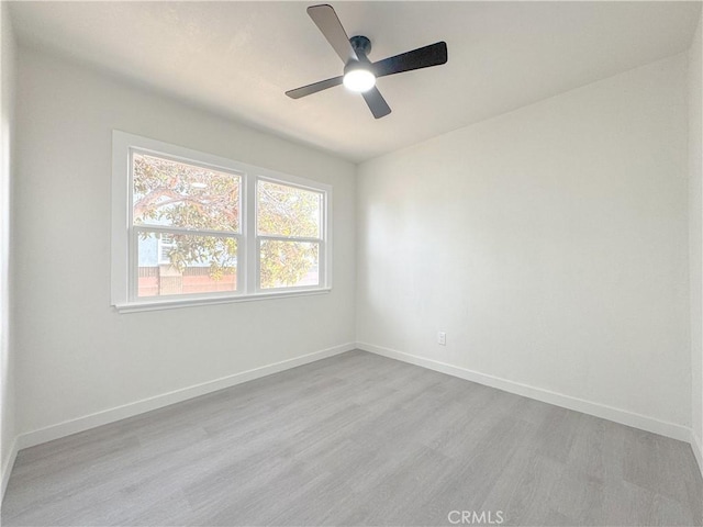 empty room with a ceiling fan, baseboards, and wood finished floors