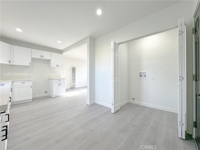 kitchen with white cabinets, recessed lighting, and light wood-style floors