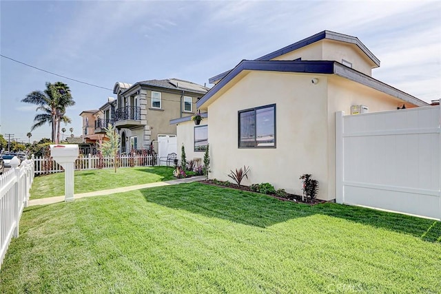 exterior space with a front lawn, fence private yard, and stucco siding