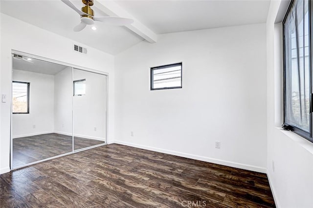 unfurnished bedroom featuring visible vents, lofted ceiling with beams, baseboards, and wood finished floors