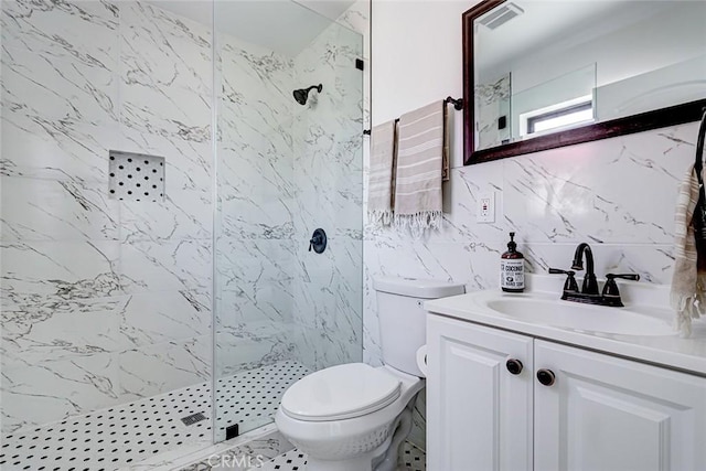 bathroom featuring vanity, tile walls, toilet, and a marble finish shower