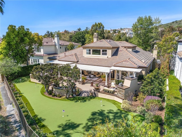 10 Corte Vizcaya, San Clemente, CA 92673 - back of house featuring an area to practice putting, a tiled roof, a patio area, and a chimney