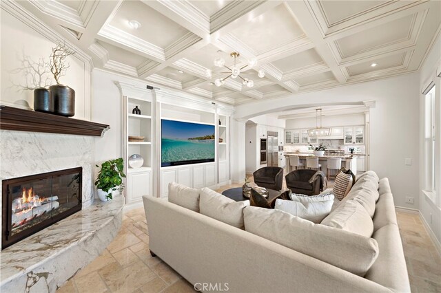 10 Corte Vizcaya, San Clemente, CA 92673 - living area featuring stone tile floors, a fireplace, arched walkways, a chandelier, and coffered ceiling