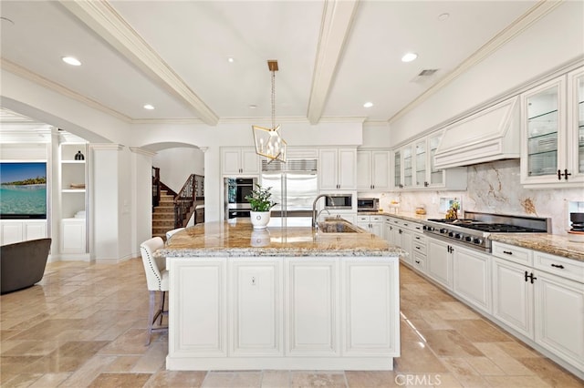 10 Corte Vizcaya, San Clemente, CA 92673 - kitchen with decorative columns, a sink, appliances with stainless steel finishes, light stone countertops, and a kitchen island with sink