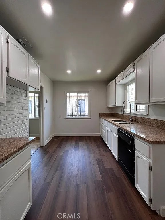 kitchen featuring dark wood-style floors, dishwasher, white cabinetry, and a sink