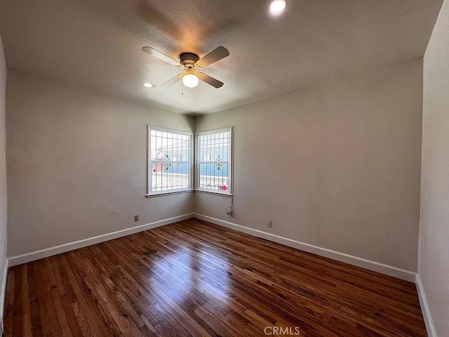 spare room with baseboards, a textured ceiling, ceiling fan, and dark wood-style flooring