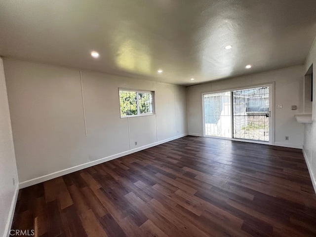 unfurnished room with dark wood-style floors, recessed lighting, and baseboards