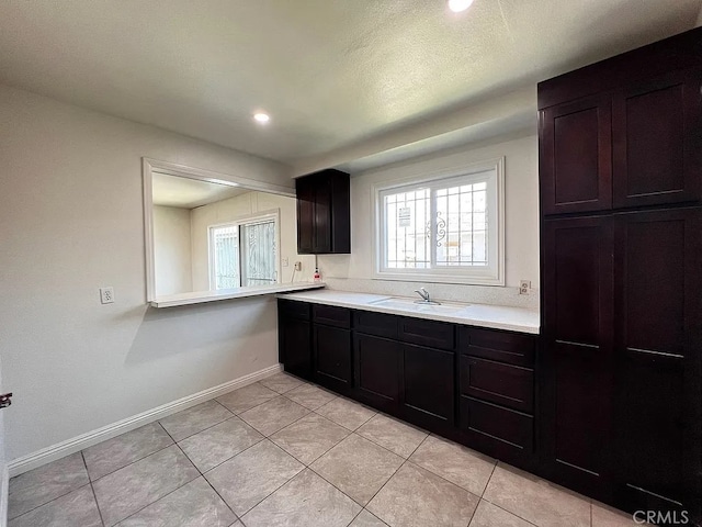 kitchen with plenty of natural light, light countertops, baseboards, and a sink