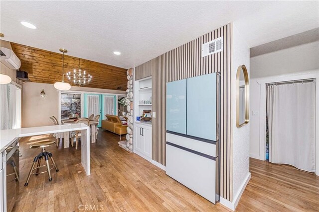 37751 Foxfield Rd, Angelus Oaks, CA 92305 - kitchen featuring visible vents, pendant lighting, light wood-style flooring, a textured ceiling, and a chandelier
