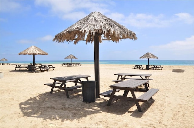 view of property's community with a water view and a beach view