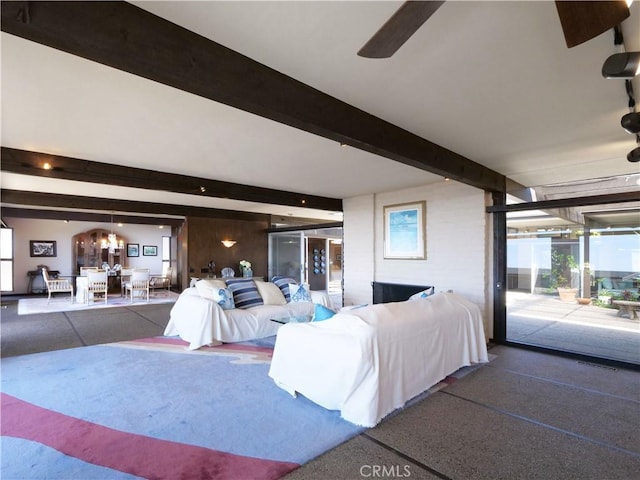 living area featuring beamed ceiling and a ceiling fan