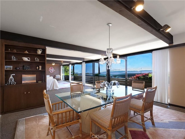 dining space with a chandelier and beamed ceiling