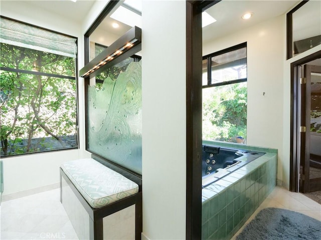 bathroom with tile patterned flooring, recessed lighting, a tub with jets, and a wealth of natural light