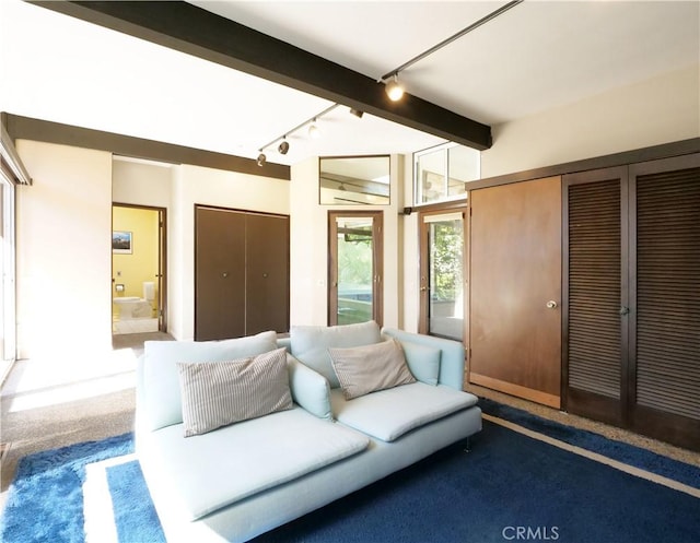 living room featuring beamed ceiling and carpet flooring