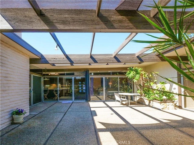 view of patio featuring glass enclosure